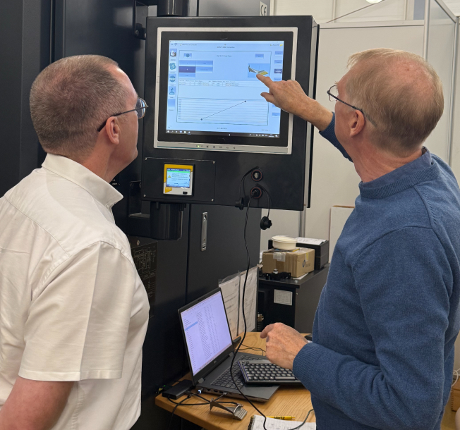 NCMT trainer providing hands-on CNC control training to engineers at Makino machine interface in UK facility.