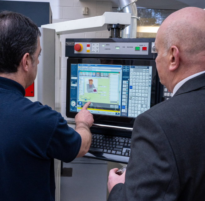 NCMT engineer guiding customer through CNC control programming during on-site machine operation training.