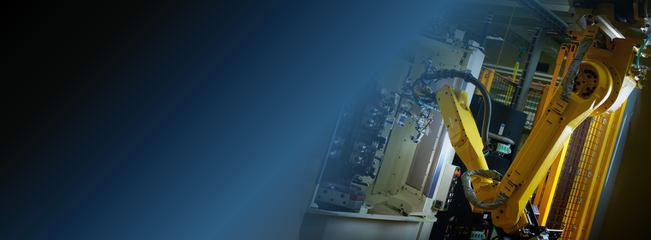 Industrial robot arm operating beside CNC equipment within an automated manufacturing cell.