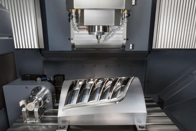Large-format 5-axis CNC machining centre producing complex mould tool component, showcasing high-precision multi-axis milling capability.