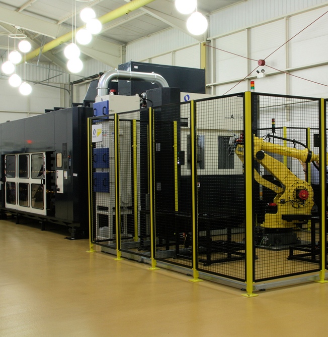 tunkymachine Large Makino automated CNC machining cell with industrial robot inside a safety enclosure in a manufacturing facility.