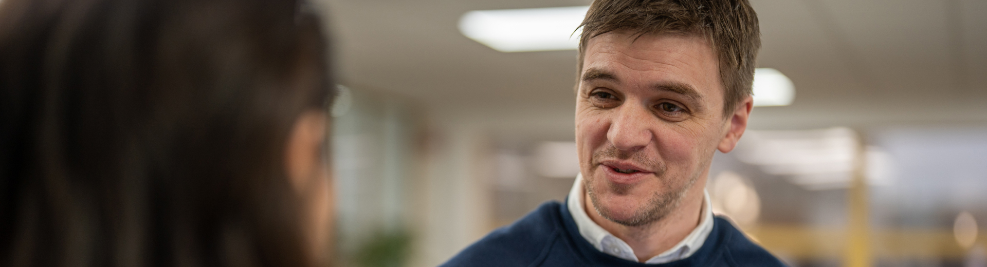 NCMT engineer discussing precision machining solutions with a colleague in the technical support office.