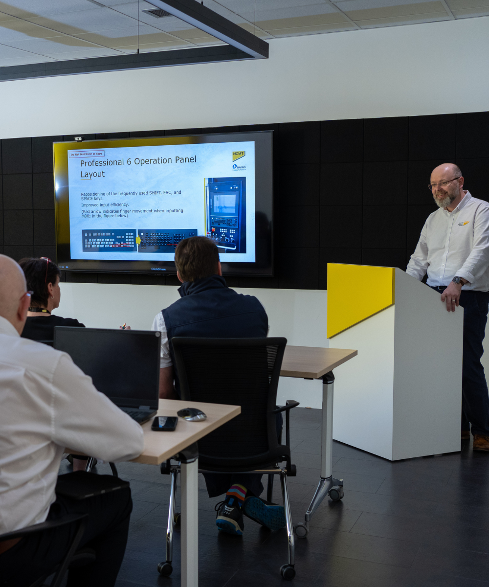 Training - substitute photo NCMT applications specialist delivering CNC programming training session to engineers in Coventry Technology Centre classroom.